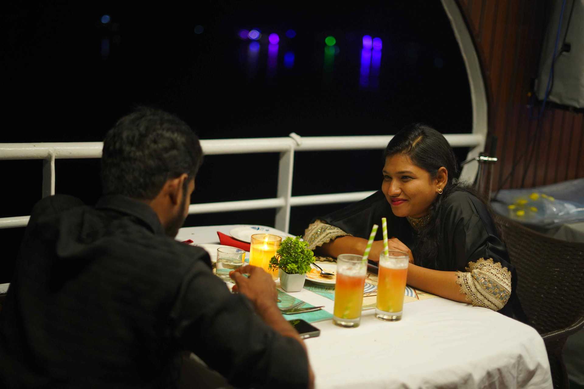 Guests enjoying drinks and dinner on board at night