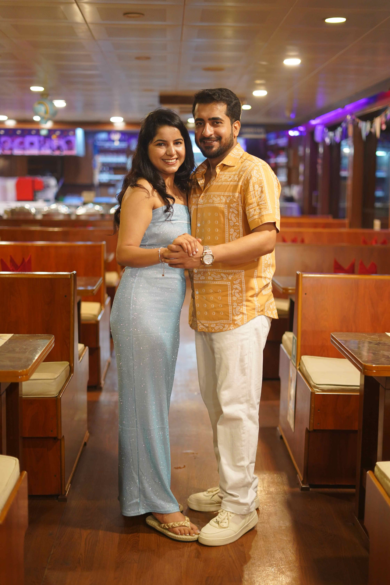 A couple posing inside the illuminated dinner cruise cabin