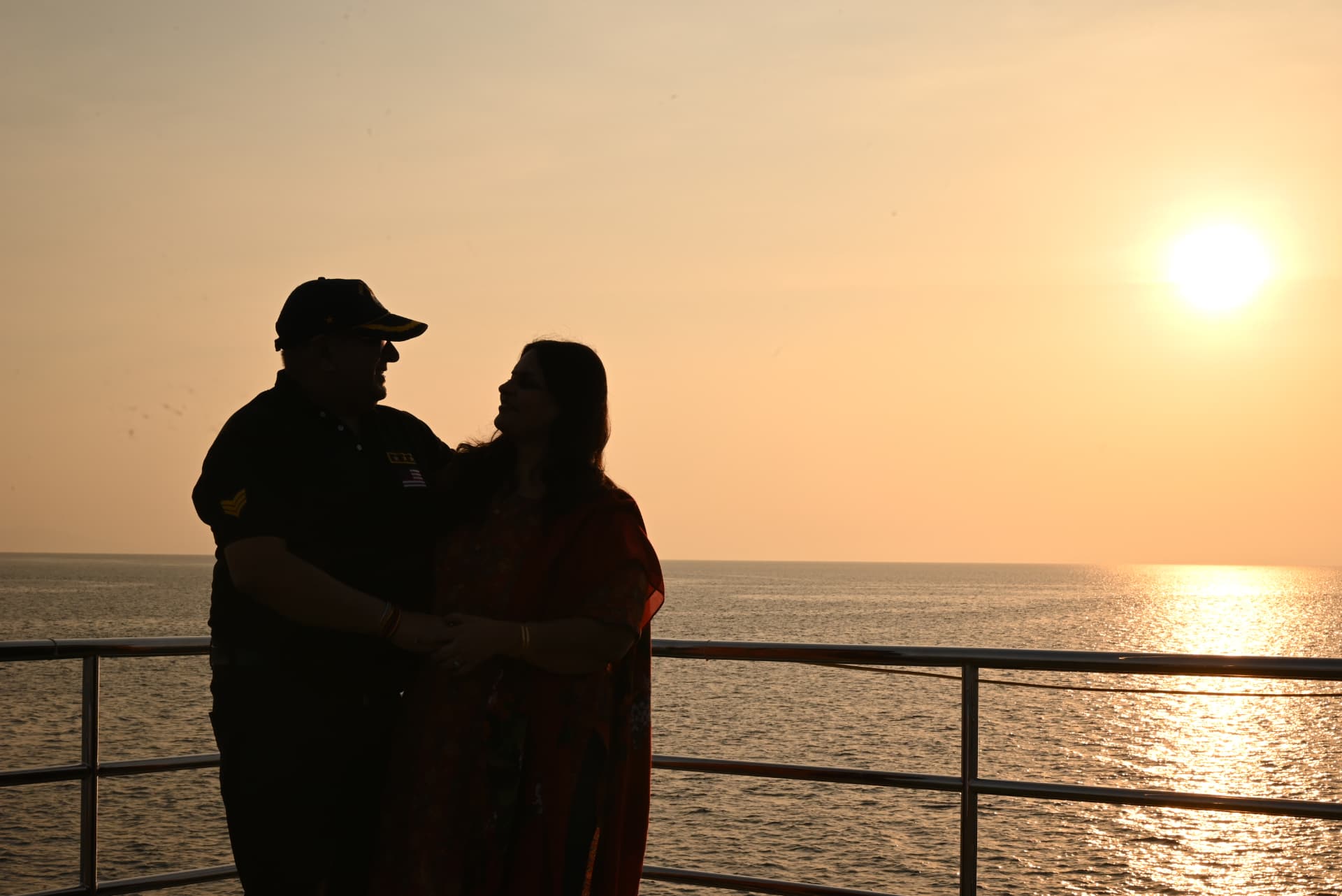 A couple silhouetted against the setting sun on the sunset cruise